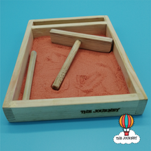Load image into Gallery viewer, Sand tray with geometric lines and shapes with wooden tools, with 'The Journey' branding.