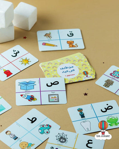 Educational cards with Arabic letters and illustrations on a beige surface
